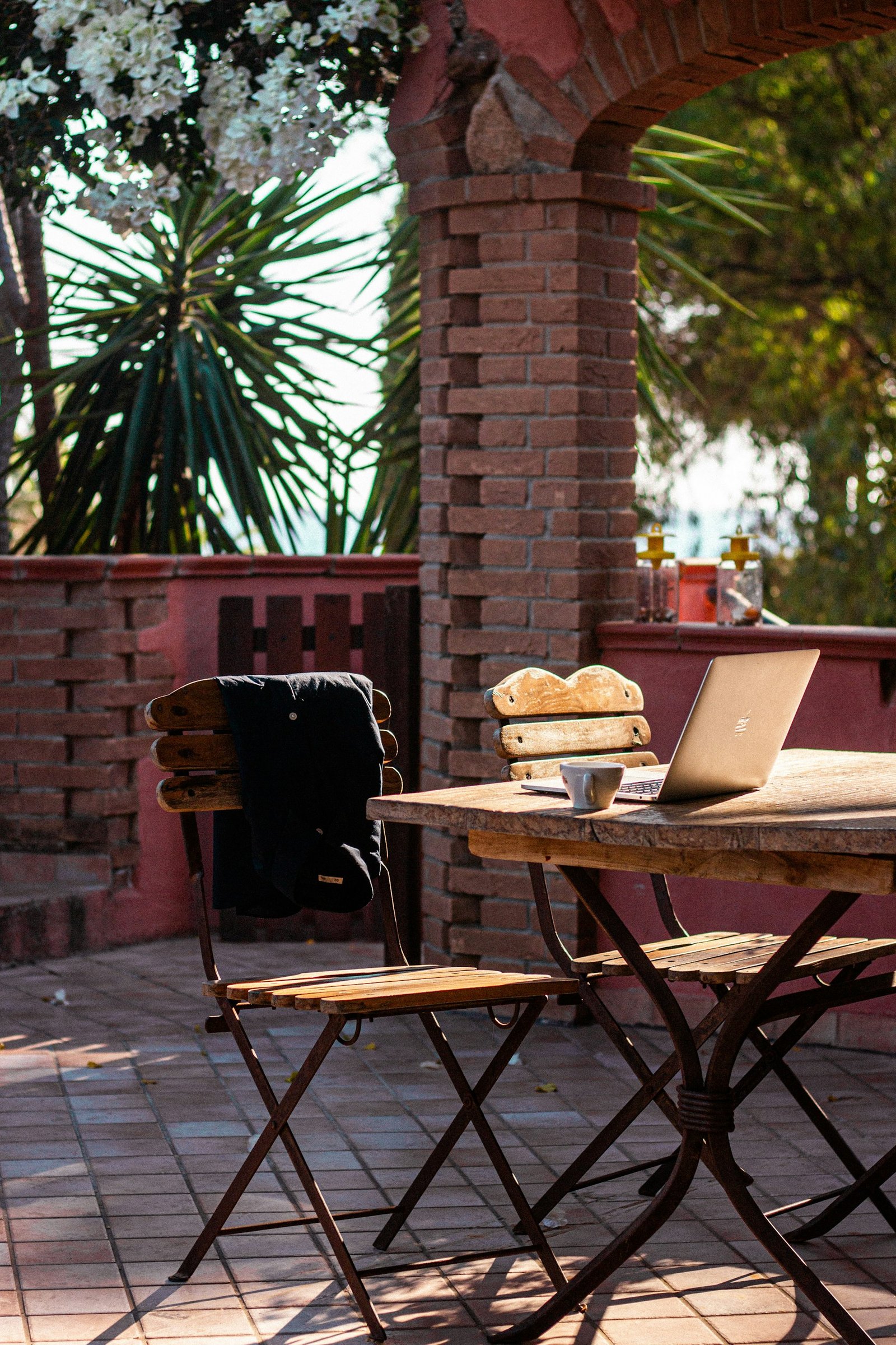 Laptop and coffee on a sunny Mediterranean terrace